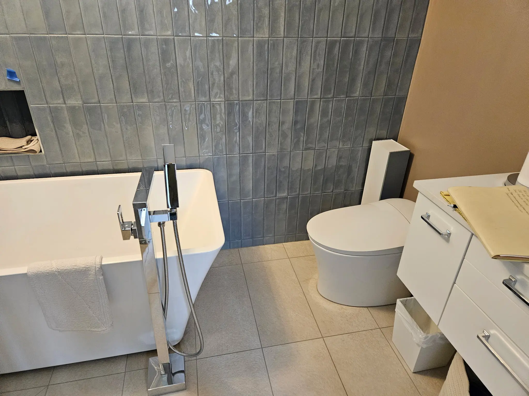 Finished bathroom with a freestanding soaking tub against vertical slate tile