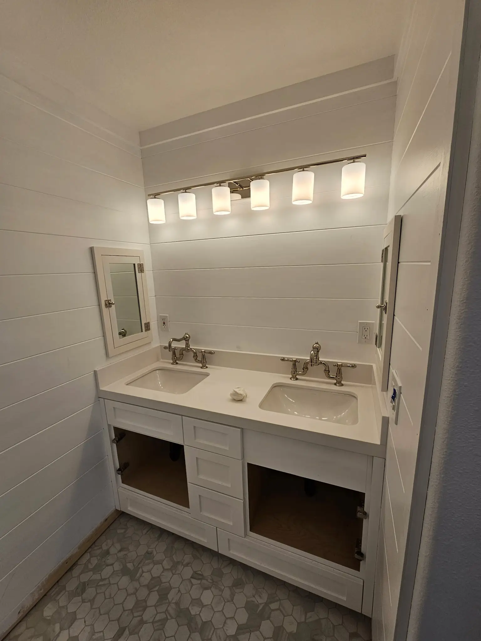 Custom double vanity with open shelving, shiplap wall and sconce lighting