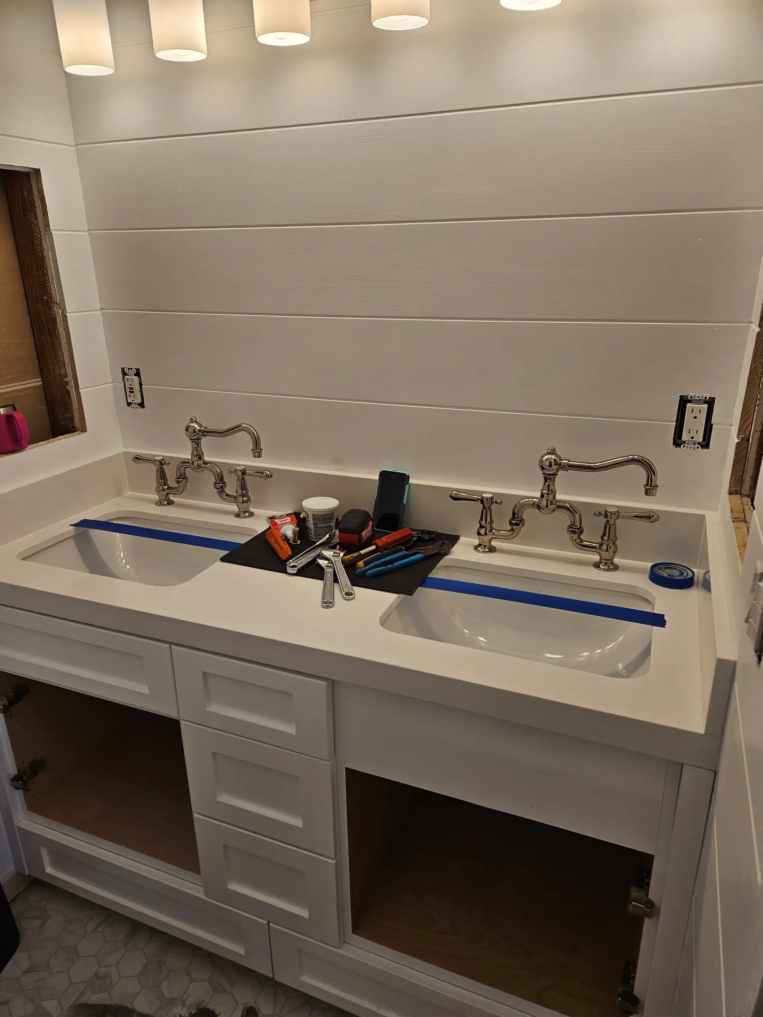 Double vanity mid-installation with tools and masking tape on the counter