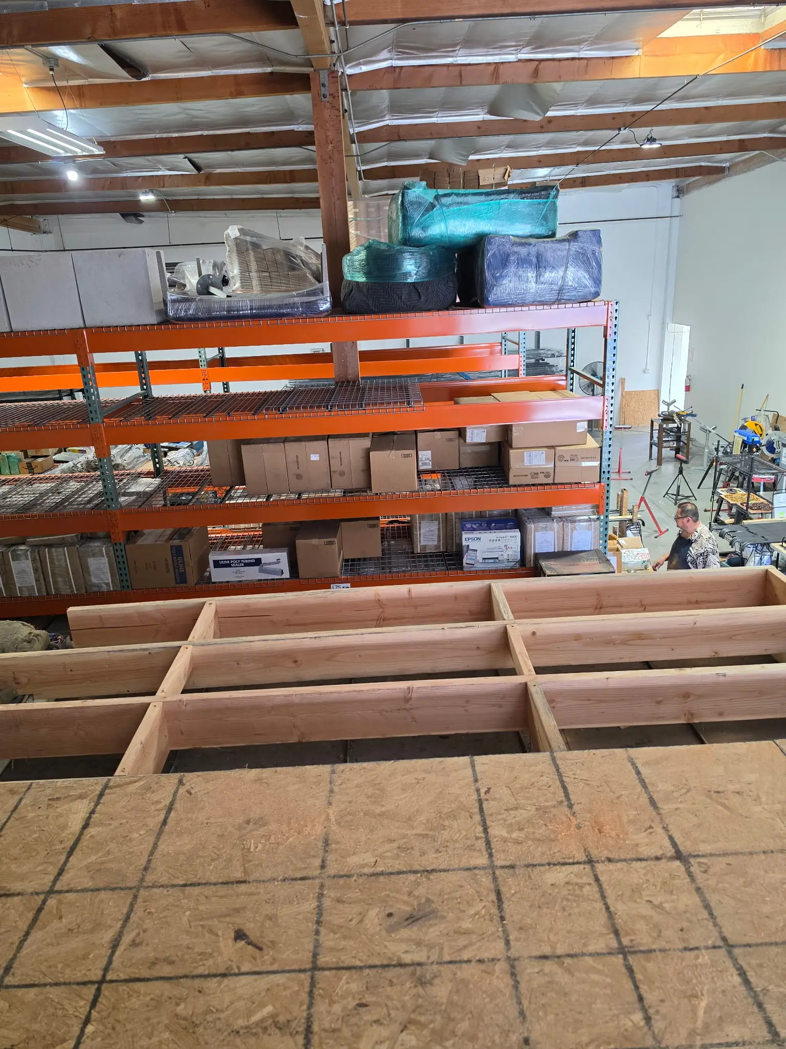 Timber framing for a mezzanine platform inside a warehouse with steel racking